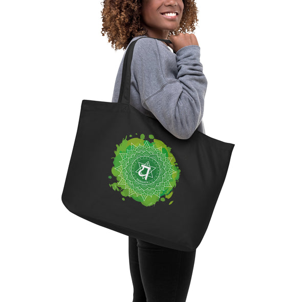 Image of a woman holding the Large organic tote bag featuring Ajna and Anahata Chakras design, perfect for yoga enthusiasts to carry your gear, showing the Anahata Chakras.