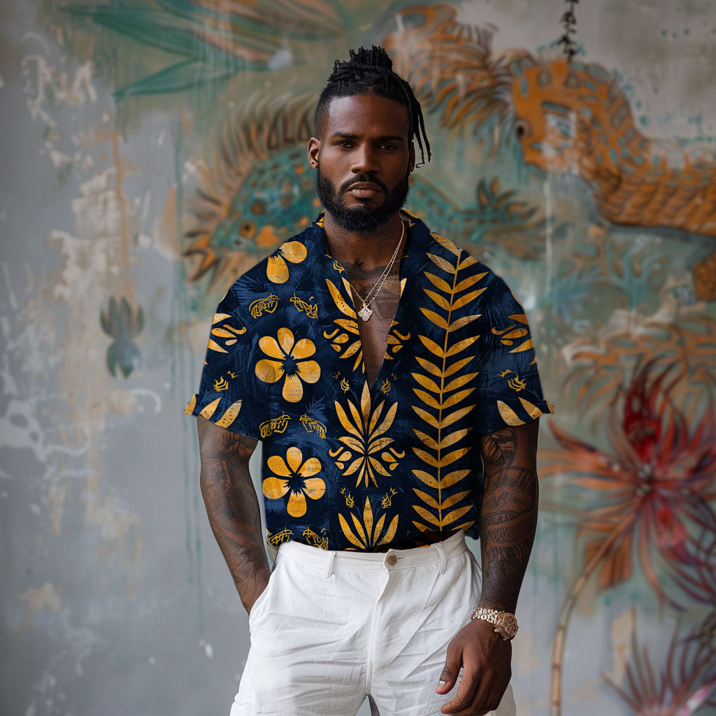 Man wearing the Golden Azure Camp Shirt from Amerukhan Basics Clothing, inspired by Egyptian styles and featuring symbolic floral images, standing in front of a mural. Front view.