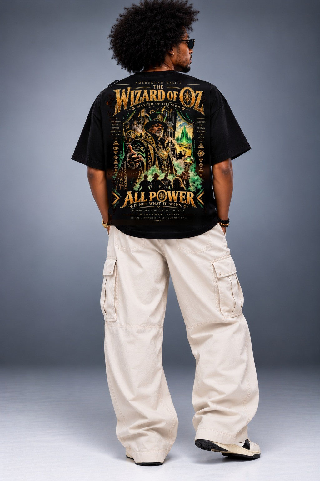 Model wearing The Wizard Black heritage Wizard of Oz graphic tee, back view with oversized black tee and cream cargo pants